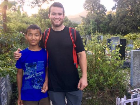 Daniel Cook is posing next to a child in India during the first month of his mission trip.