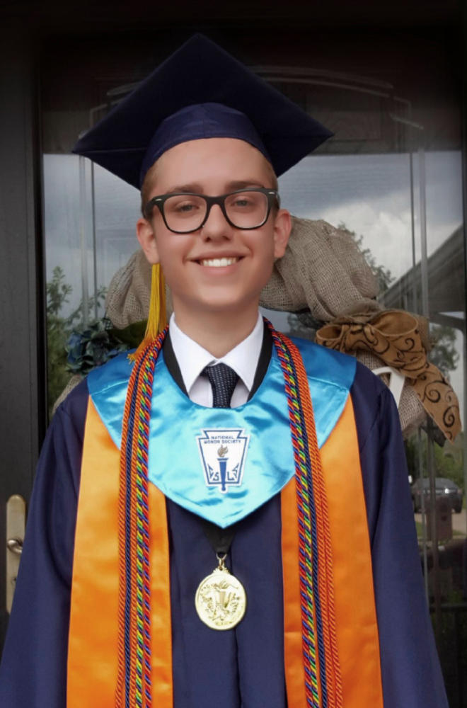 Zach Adams, Blackman 2017 alumnus, smiles bright in full graduate gear. 