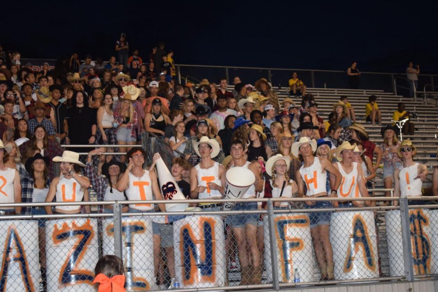 Students watch and show their support to the football team as they play in the third inning.