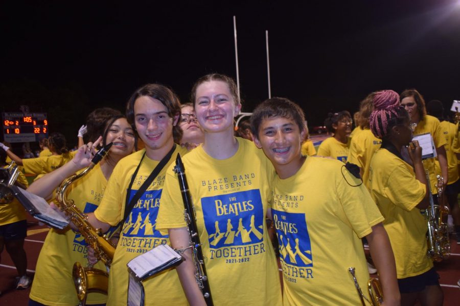 Three sophomore band members prepare to play the half-time show.