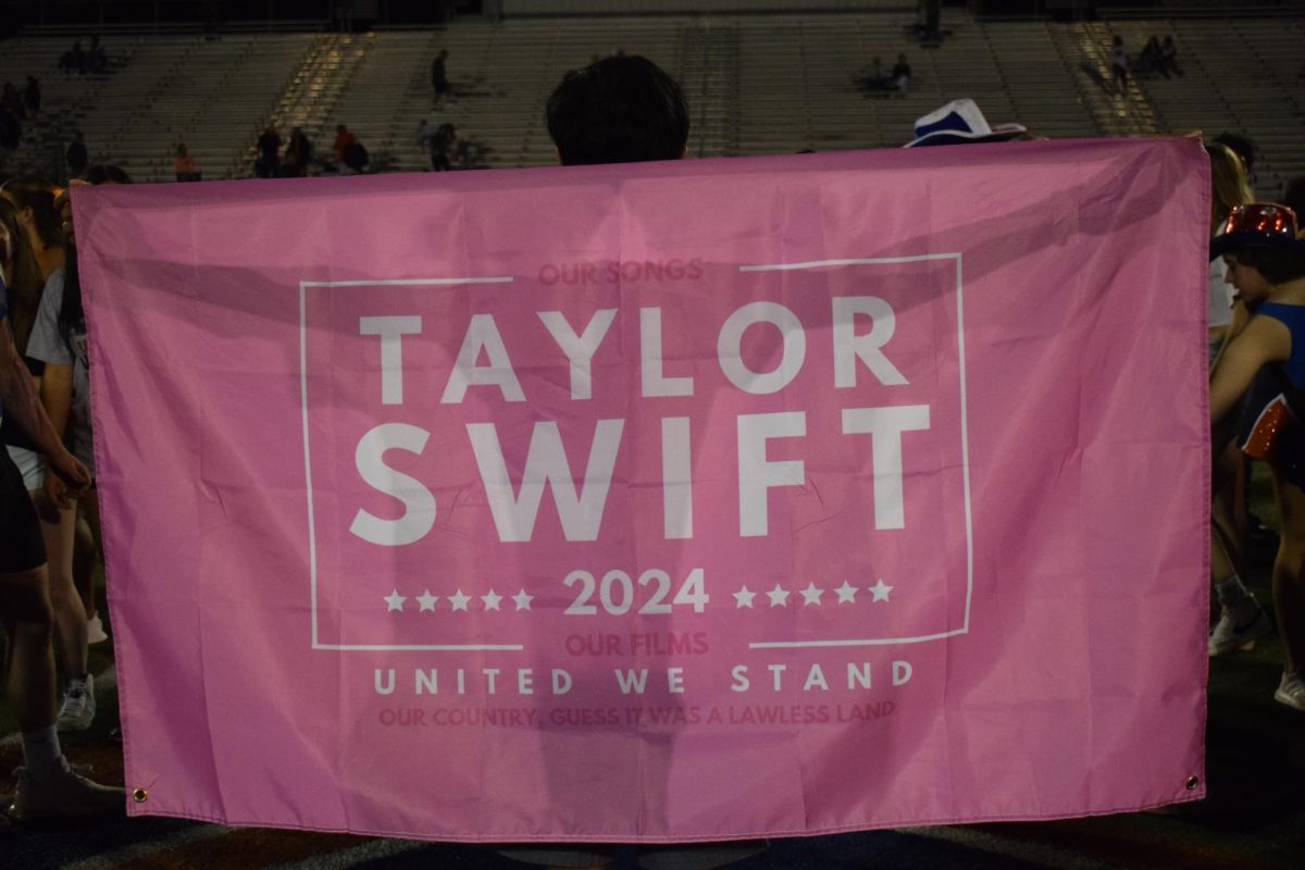 Harsh Patel holding a Taylor Swift 2024 flag.