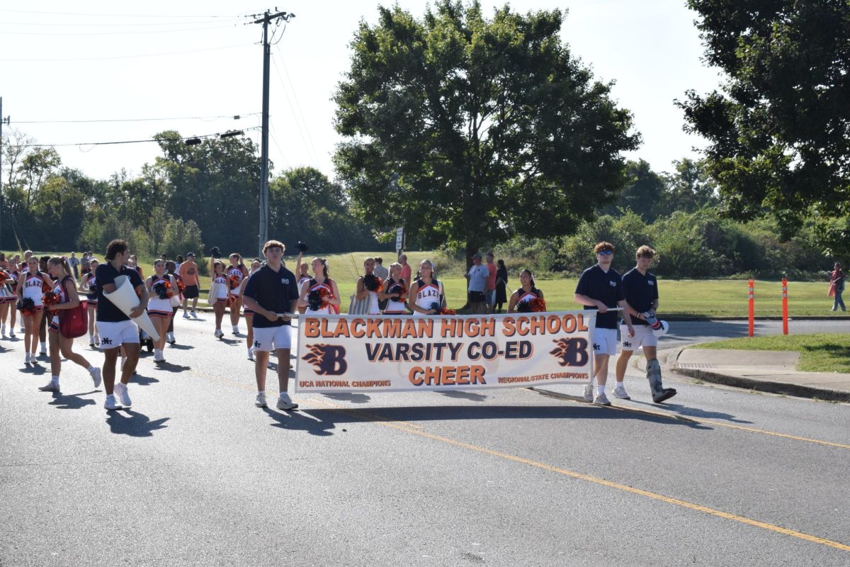 Varsity Cheer marching with sign