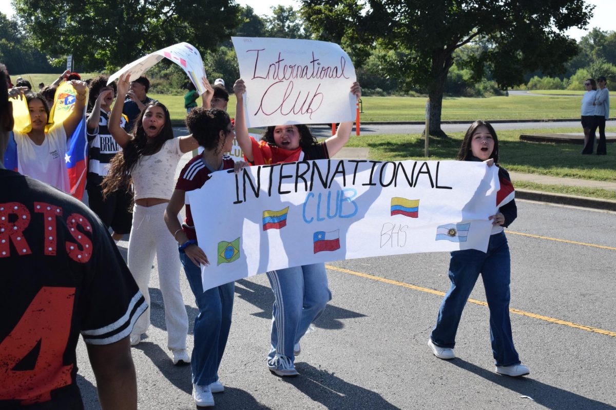 International club holding up signs marching in the parade