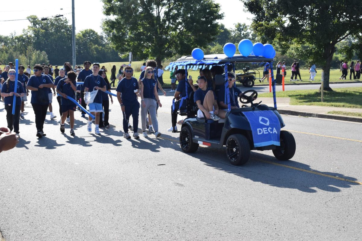DECA golfcart with people following close by