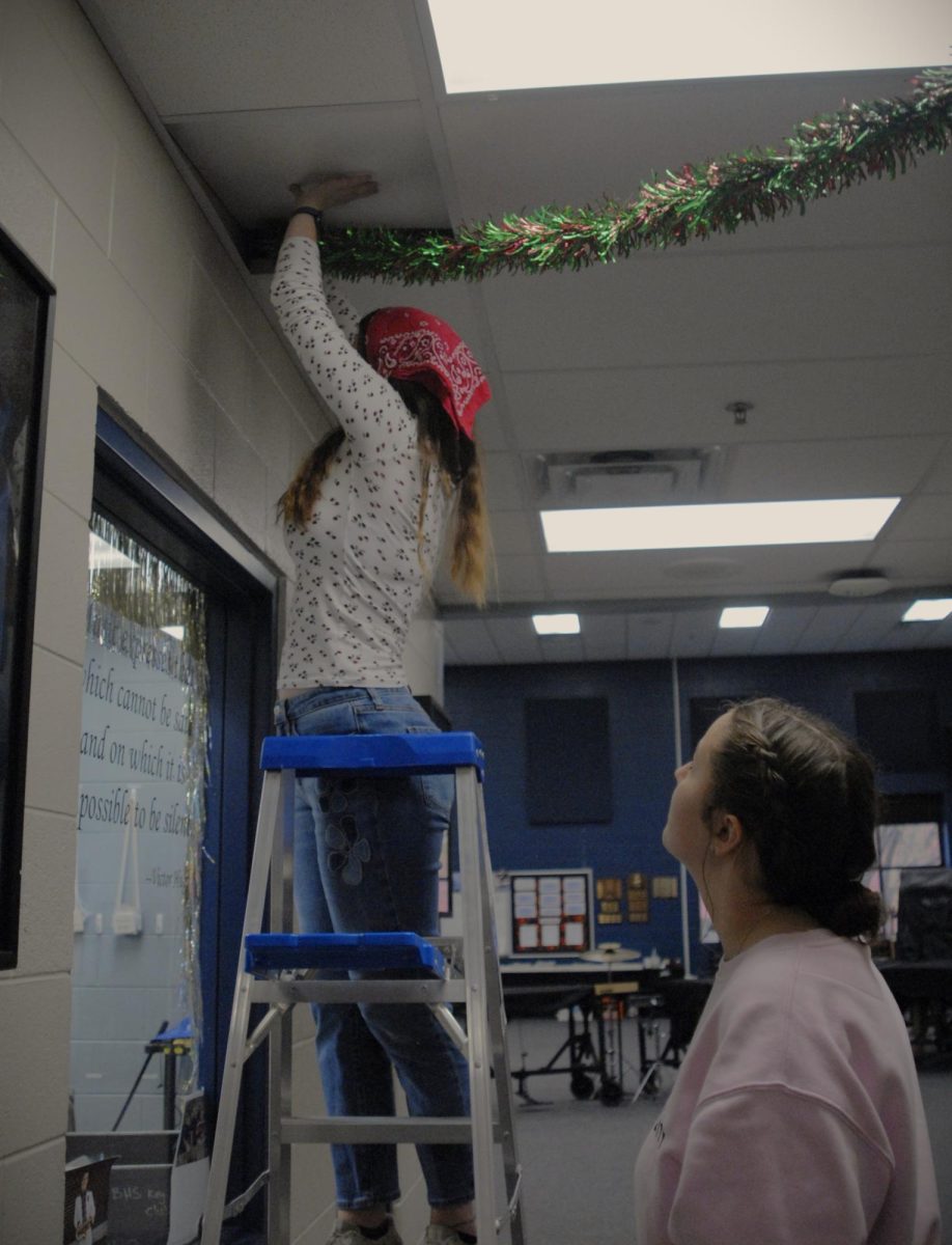 Madison Stoermer and Jenna Andersen decorating the band room for Christmas 